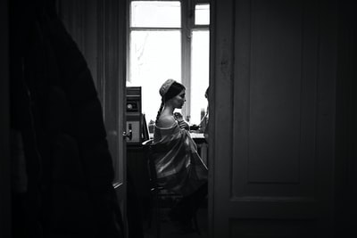 The man standing beside the mirror wearing a black jacket
